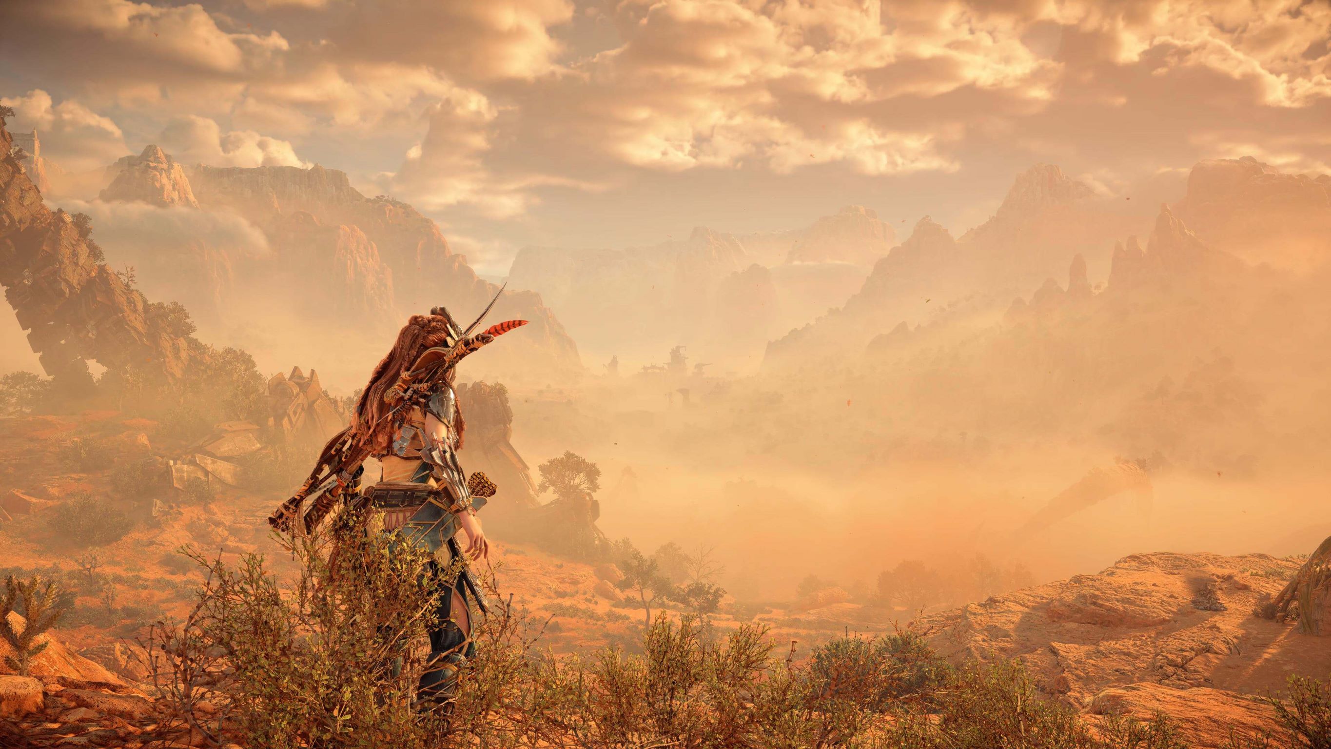 Horizon games heroine, Aloy, standing on a hill overlooking a medieval fortress